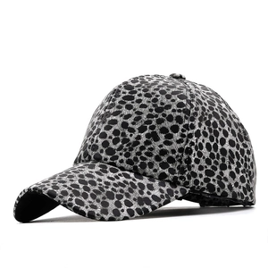 Fashionable baseball cap with dark leopard print and curved brim in faux leather finish