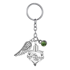 Close-up of angel wing and heart memorial keychain with green crystal and engraving