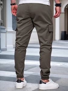 Rear view of men's olive green slim fit cargo joggers showing large utility side pockets