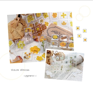 Detailed view of yellow flower botanical stickers and 3D acrylic charms for DIY scrapbooking