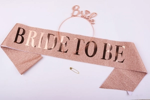 Detail view of rose gold glitter sash with BRIDE TO BE text and metal Bride headband set