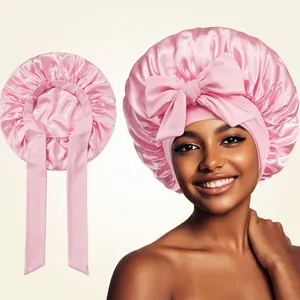Pink satin hair bonnet for sleeping featuring a large silk-like bow for women's hair care