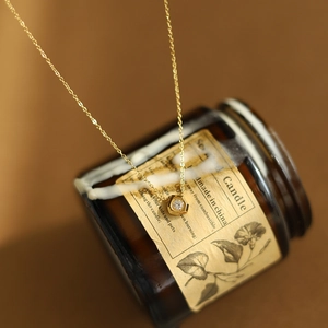 18K gold plated titanium necklace with hexagonal white diamond pendant on candle holder