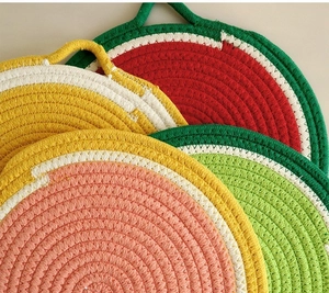 Detail of colorful fruit-shaped cotton rope coasters with hanging loops and woven texture