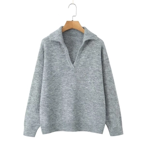 Détail du pull en maille grise avec col polo et texture douce sur cintre en bois