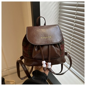 Detailansicht des Vintage-Rucksacks mit Karomuster, Lederbesatz und modischem Schriftzug