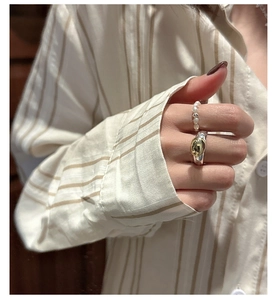 Detail of stacked S925 silver two-tone metal ring and beaded pearl elastic ring