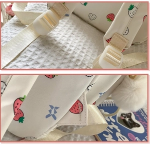 Close-up of adjustable shoulder straps and strawberry print on a cute white school backpack