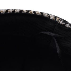 Detail of tweed octagonal hat featuring a black sweatband and adjustable drawstring