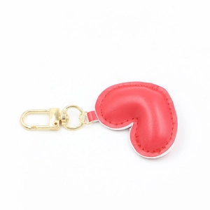 Close-up of a red heart-shaped PU leather keychain with a golden metal hook and ring