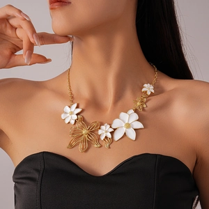 Detail of floral enamel necklace with gold plating shown on a model neck