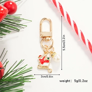 Detail showing Santa Claus enamel keychain with gold clasp and pearl charm decoration