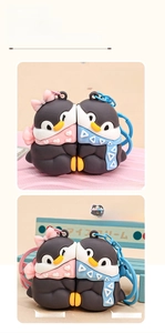 Detail view of magnetic penguin couple keychains in pink and blue soft silicone