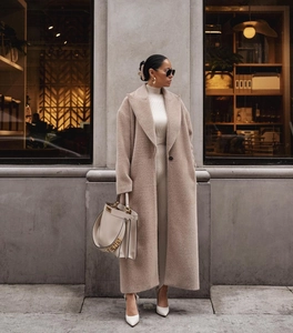 Détail de la texture en laine beige et du revers classique sur ce manteau long pour femme
