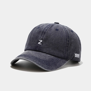 Détail macro d'une casquette en denim délavé bleu avec broderie de la lettre Z et 1999