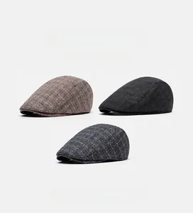 Flat lay of retro British flat caps in coffee twill and grey plaid patterns