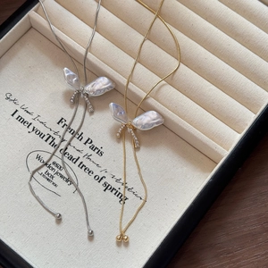 Macro detail of butterfly pendant with mother-of-pearl inlay and micro-pave diamond accents