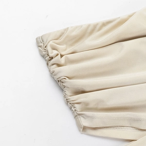 Détail d'une robe en satin champagne montrant les fronces élastiques et la texture