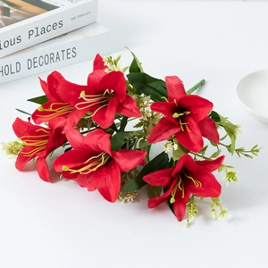 Artificial red lily bouquet with green leaves and white accents in professional studio shot