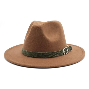 Dettaglio del cappello fedora marrone con fascia in pelle intrecciata verde e fibbia argentata