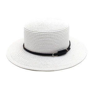 Détail du chapeau de paille blanc à bord plat avec ruban en cuir noir et boucle en métal