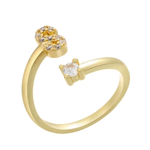 Detail of gold-plated open ring featuring a micro-paved S-shape and a prong-set cubic zirconia