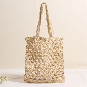 Beige hollow straw woven shoulder bag with natural mesh texture for beach vacations