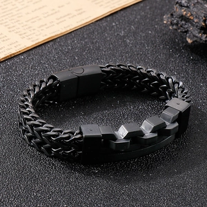 Close-up of a matte black titanium steel bracelet with a double-row woven chain design