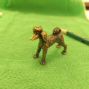 Detailed view of antique brass poodle figurine showing textured metallic fur and craft finish