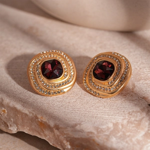 Macro shot of vintage gold stud earrings with oval red gemstone and crystal halo