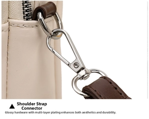 Macro shot of durable silver lobster clasp and D-ring on cream faux leather bag