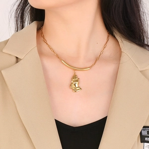 Collier en acier titane doré avec pendentif main de prière porté par un mannequin