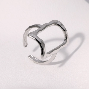 Detailed view of silver irregular geometric cutout ring with wavy textured finish