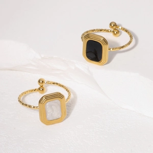 Close-up of vintage square open rings with gold texture and black and white inlay
