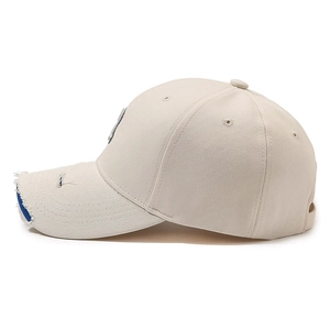 Distressed beige baseball cap with letter R embroidery and frayed blue brim detail