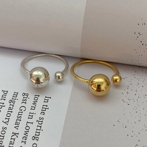 Detail view of silver and gold open rings with asymmetric spherical beads on magazines