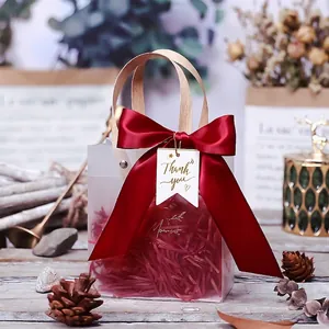 Frosted semi-transparent gift bag with red ribbon, golden 'Moment' text and wooden handle
