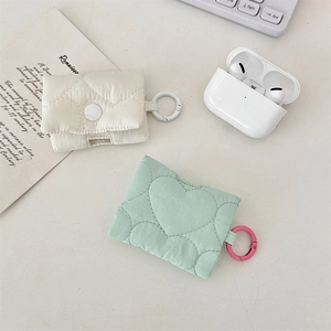 Dettaglio delle cover trapuntate per AirPods in panna a rombi e menta a cuori