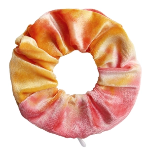 Detailed macro view of orange and pink tie-dye velvet scrunchie with soft pleated texture