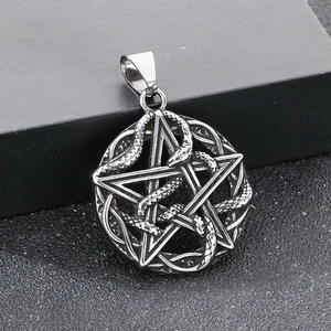 Detail of silver pentagram pendant featuring an intricate snake design on a dark box