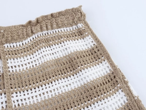 Detailed macro view of brown and white striped crochet knit fabric with hollow mesh texture