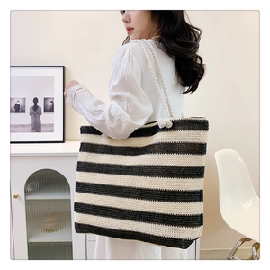 Lifestyle shot of large woven tote bag with black and white stripes and rope handles