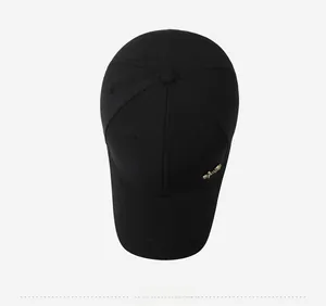 Top down view of black baseball cap showing cotton fabric texture and gold metal logo detail