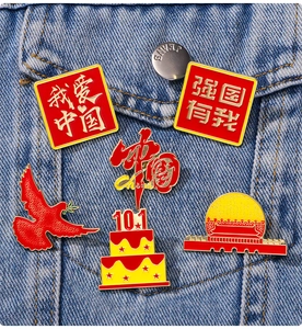 Detail of red and gold enamel lapel pins on a denim jacket featuring patriotic Chinese motifs