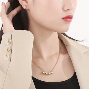 Set collana e orecchini a perno dorati con cristalli tondi indossati da modella