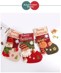 Dettaglio di tre calze di Natale in peluche con figure 3D di Babbo Natale, Pupazzo e Renna
