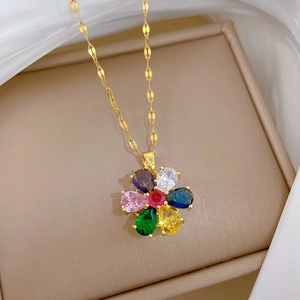 Macro view of rotating floral necklace with colorful gemstones on a gold tile chain