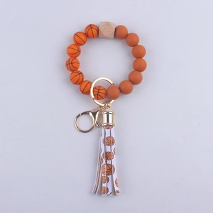 Dettaglio portachiavi a tema basket con perle in silicone e nappa in pelle PU