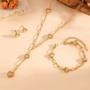 Gros plan détaillé d'un ensemble de bijoux cœur doré avec cristaux sur fond de bois naturel