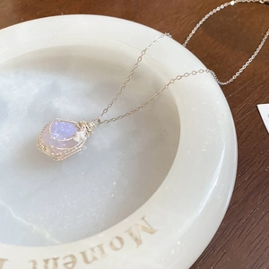 Detailed macro of handmade silver wire wrapped purple raw stone pendant necklace